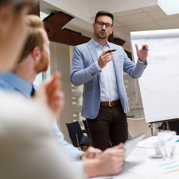 man speaking in front of business group